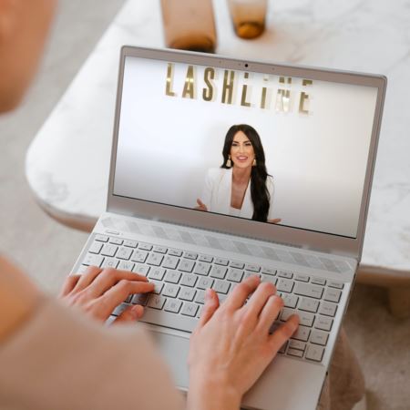 Person using laptop with lash line lash extension online course on screen