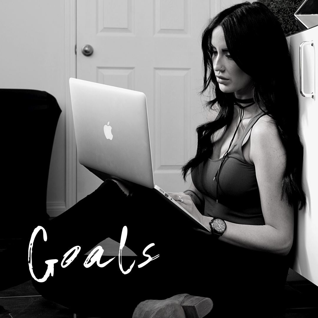 Black and white image of Lash Line co-owner Jessi on her laptop and the word 'Goals' underneath.